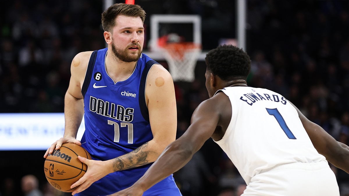 Dallas Mavericks guard Luka Doncic (77) looks to pass while Minnesota Timberwolves guard Anthony Edwards (1) defends during the first quarter at Target Center.