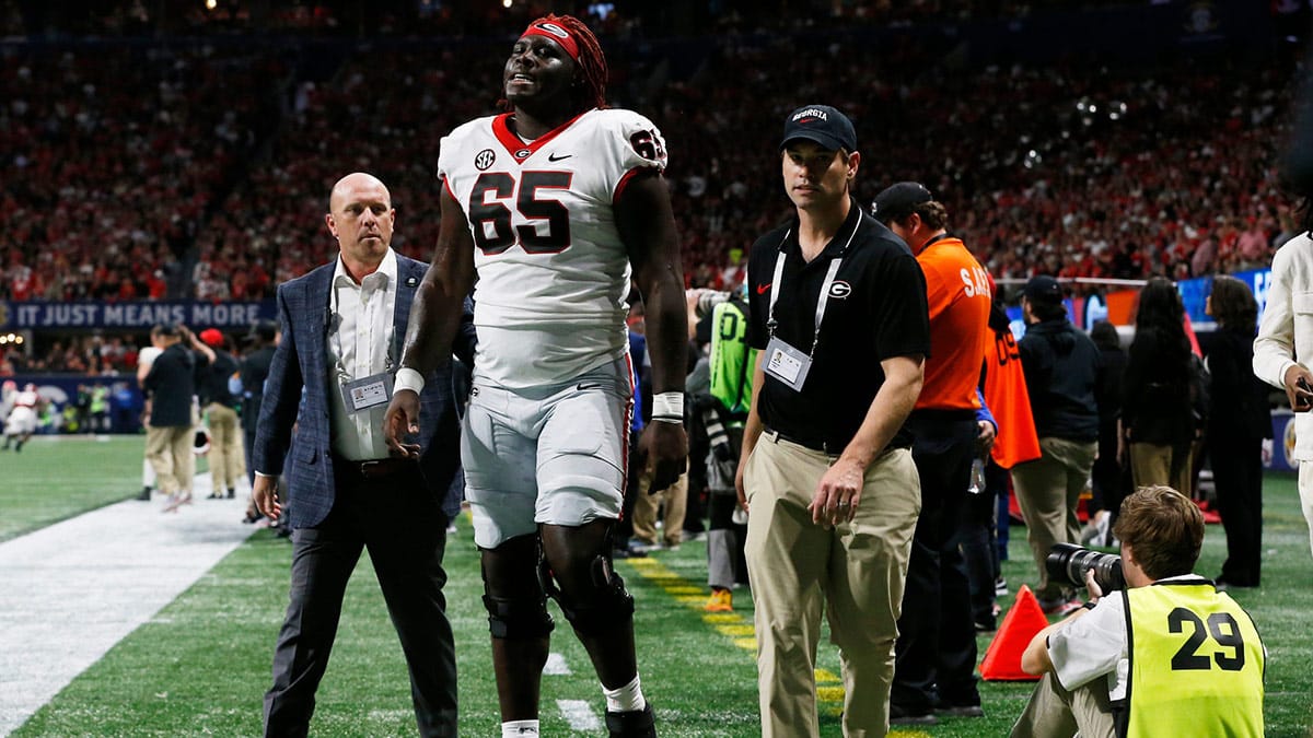 Georgia offensive lineman Amarius Mims (65) leaves the field with na injury during the first half of the SEC Championship game against Alabama at Mercedes-Benz Stadium