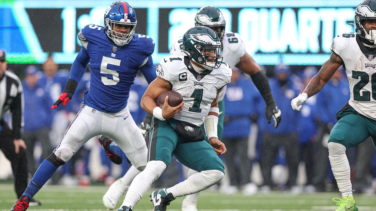Philadelphia Eagles quarterback Jalen Hurts (1) scrambles for yards in front of New York Giants defensive end Kayvon Thibodeaux (5) during the first half at MetLife Stadium.