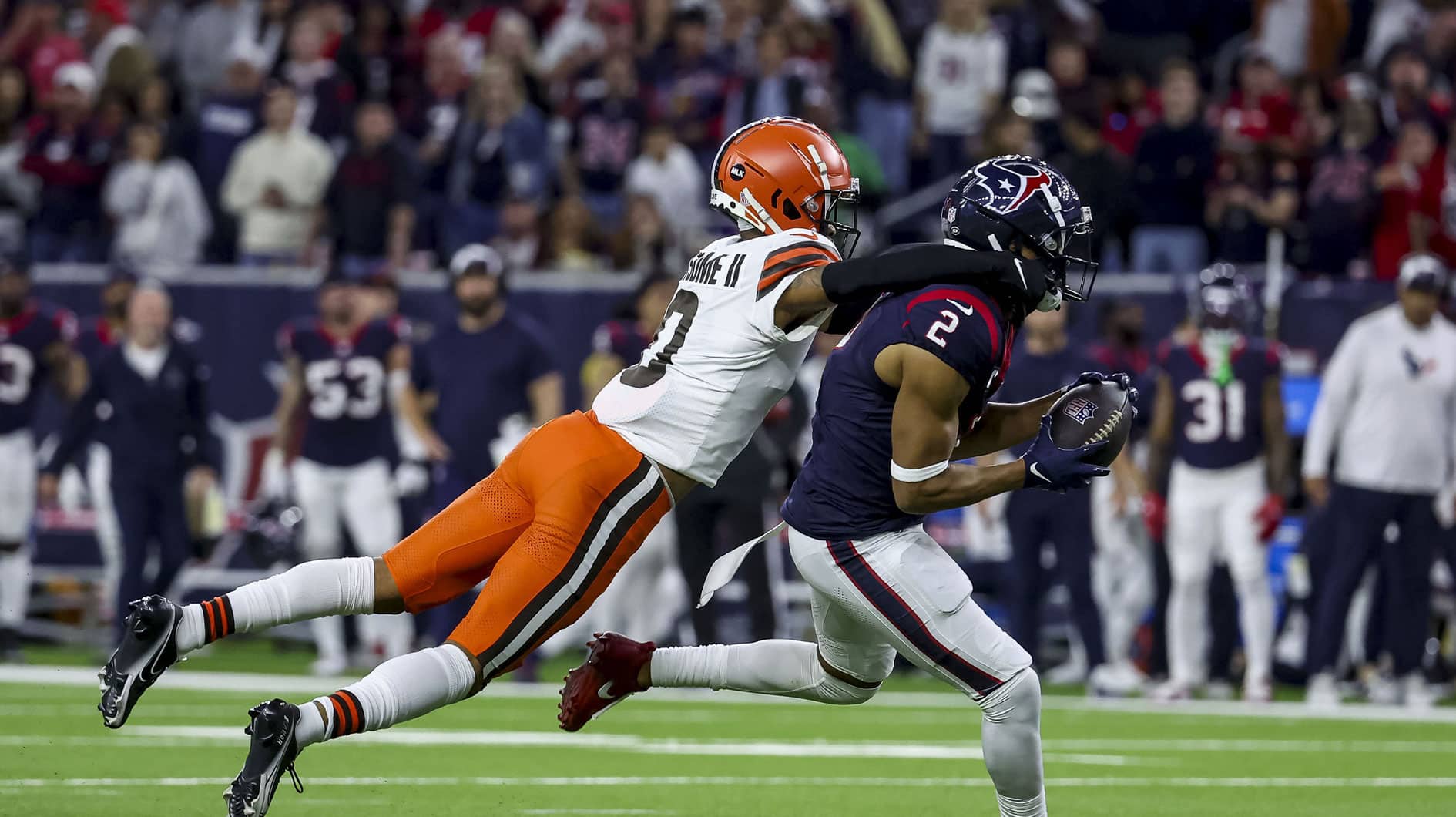 Cleveland Browns cornerback Greg Newsome II (0) tackled Houston Texans wide receiver Robert Woods (2) after an interception during the third quarter in a 2024 AFC wild card game at NRG Stadium. 