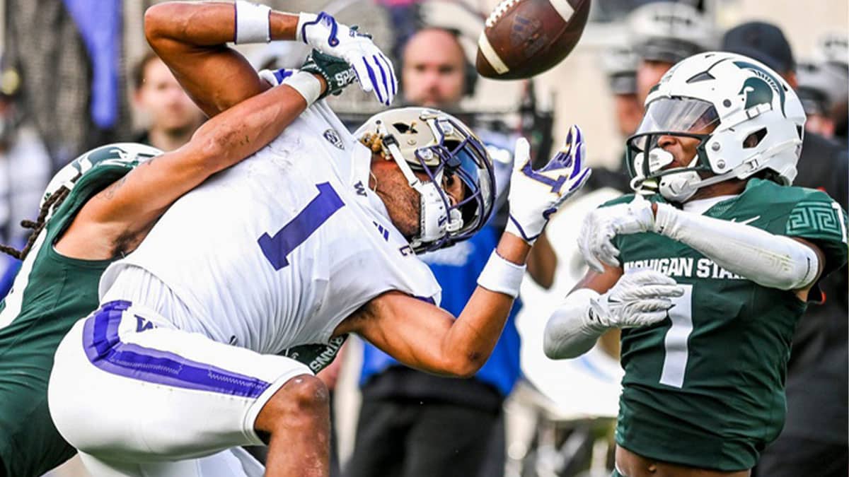 Michigan State's Marqui Lowery Jr., left, and Jaden Mangham break up a pass against Washington's Rome Odunze during the second quarter