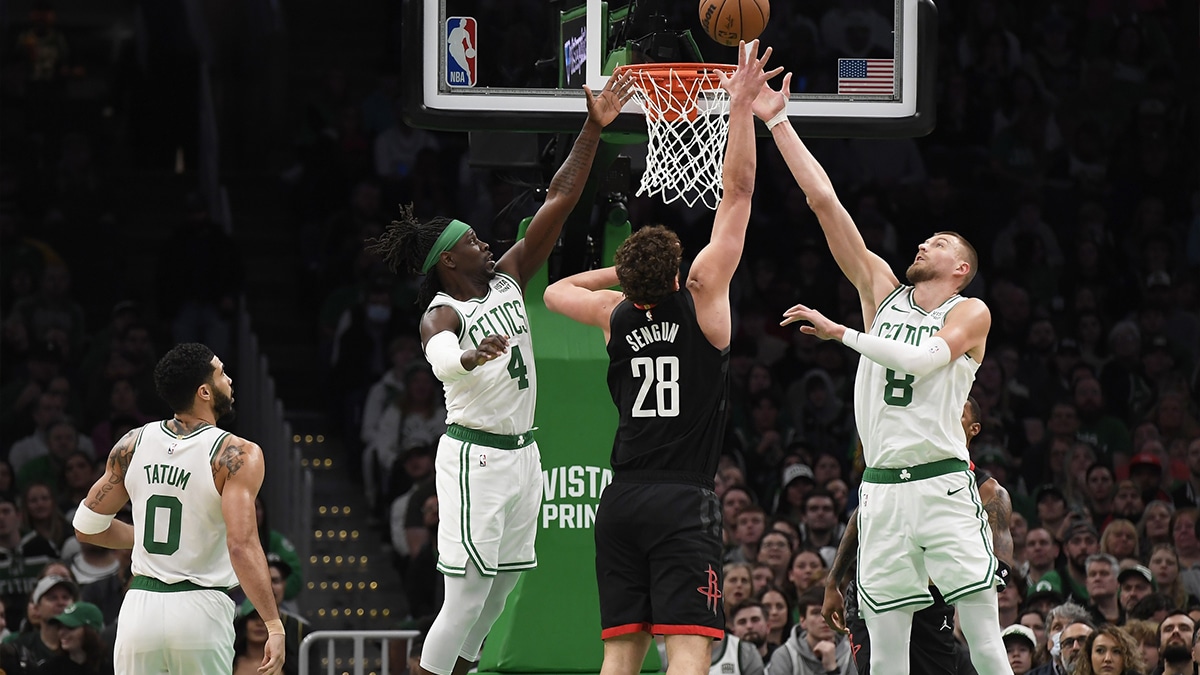 Boston Celtics guard Jrue Holiday (4) and center Kristaps Porzingis (8) and Houston Rockets center Alperen Sengun (28) battle for a rebound during the first half at TD Garden.