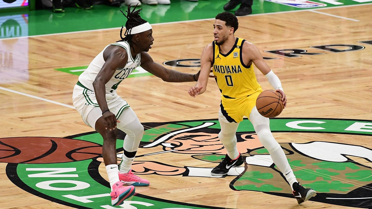Indiana Pacers guard Tyrese Haliburton (0) dribbles the ball against Boston Celtics guard Jrue Holiday (4) in overtime for game one of the eastern conference finals for the 2024 NBA playoffs at TD Garden.