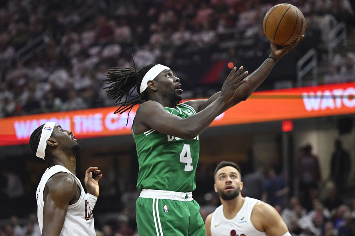 Boston Celtics guard Jrue Holiday (4) drives to the basket between Cleveland Cavaliers guard Caris LeVert (3) and guard Max Strus (1) in the second quarter of game four of the second round for the 2024 NBA playoffs at Rocket Mortgage FieldHouse.