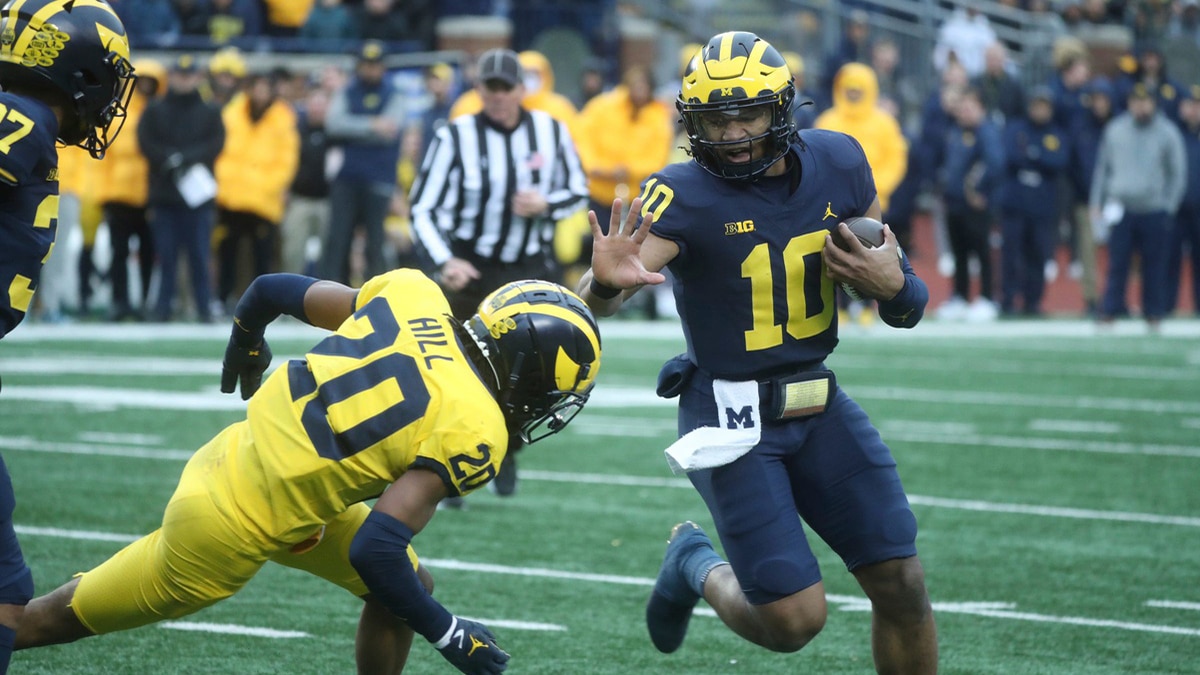 Michigan Wolverines quarterback Alex Orji (10) runs by defensive back Jyaire Hill (20) during the Michigan scrimmage on