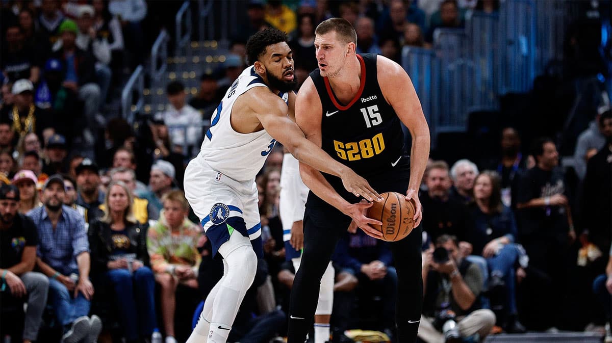 Denver Nuggets center Nikola Jokic (15) controls the ball as Minnesota Timberwolves center Karl-Anthony Towns (32) guards in the first quarter during game two of the second round for the 2024 NBA playoffs at Ball Arena. 