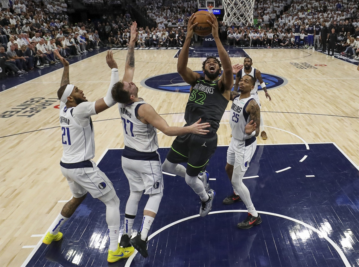 Minnesota Timberwolves center Karl-Anthony Towns (32) shoots against Dallas Mavericks guard Luka Doncic (77) during game five of the western conference finals for the 2024 NBA playoffs at Target Center. 