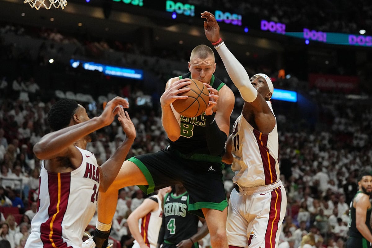 Boston Celtics center Kristaps Porzingis (8) grabs a rebound over Miami Heat center Bam Adebayo (13) in the first half during game three of the first round for the 2024 NBA playoffs at Kaseya Center.