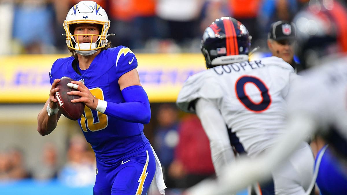 Los Angeles Chargers quarterback Justin Herbert (10) moves out to pass against the defense of Denver Broncos linebacker Jonathon Cooper (0)