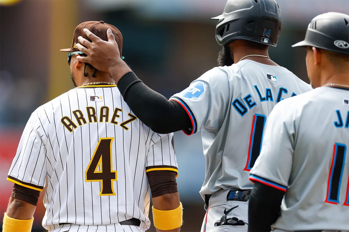 Miami Marlins designated hitter Bryan De La Cruz (14) embraces his former teammate San Diego Padres first baseman Luis Arraez (4) at first base after hitting a single in the first inning against the San Diego Padres at Petco Park.