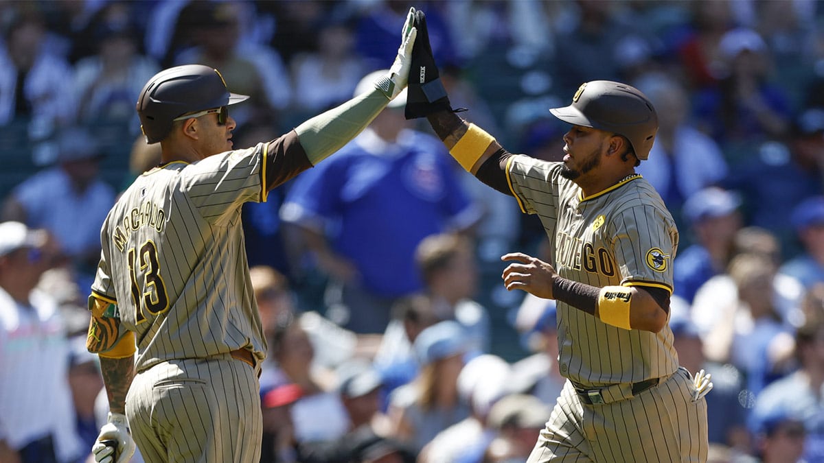 San Diego Padres second baseman Luis Arraez (4) celebrates with third baseman Manny Machado (13) after scoring against the Chicago Cubs during the fifth inning at Wrigley Field.