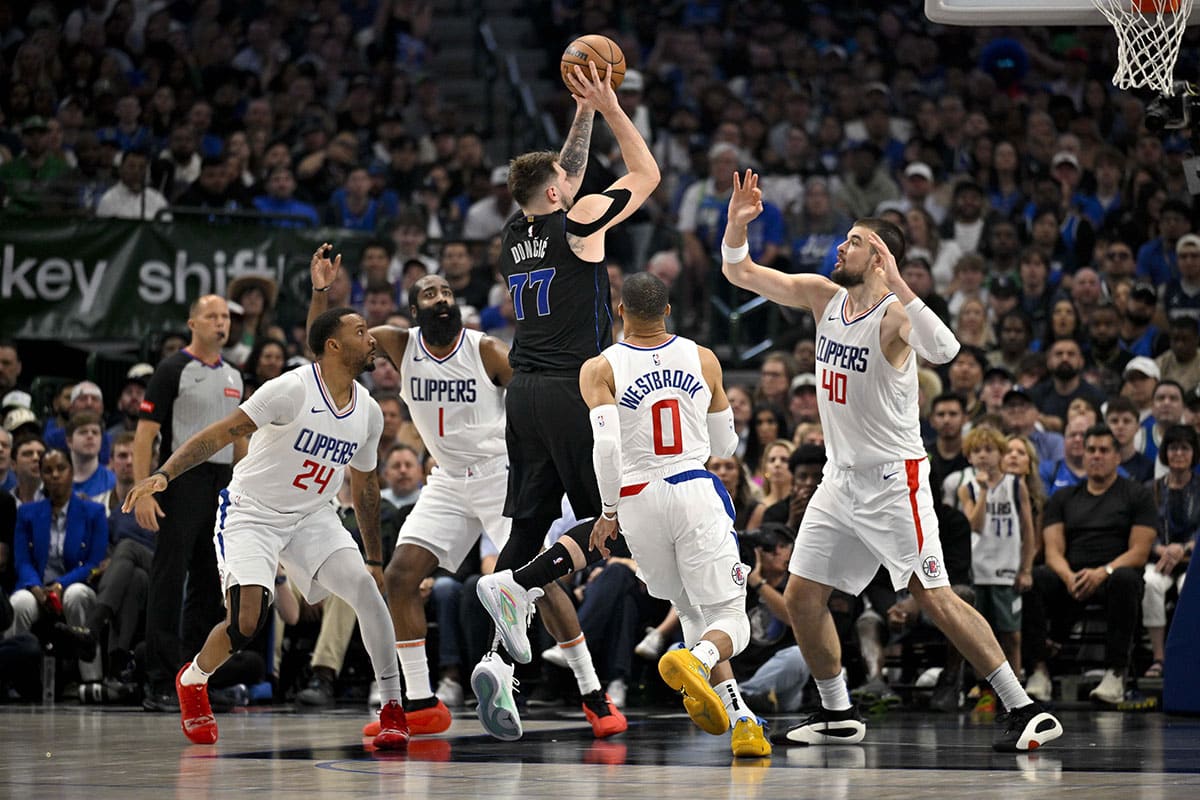Dallas Mavericks guard Luka Doncic (77) passes the ball over LA Clippers guard Norman Powell (24) and guard James Harden (1) and guard Russell Westbrook (0) and center Ivica Zubac (40) during the first quarter during game six of the first round for the 2024 NBA playoffs at American Airlines Center. 