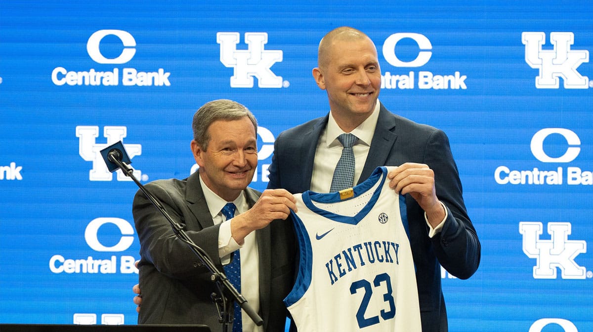 University of Kentucky Athletic Director Mitch Barnhart and new men’s basketball coach Mark Pope hold a new basketball jersey up during Pope’s press conference