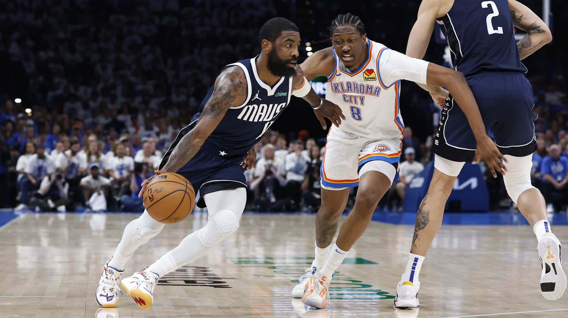 Mavericks guard Kyrie Irving (11) moves around Oklahoma City Thunder forward Jalen Williams (8) on a play during the second half of game one of the second round for the 2024 NBA playoffs at Paycom Center.