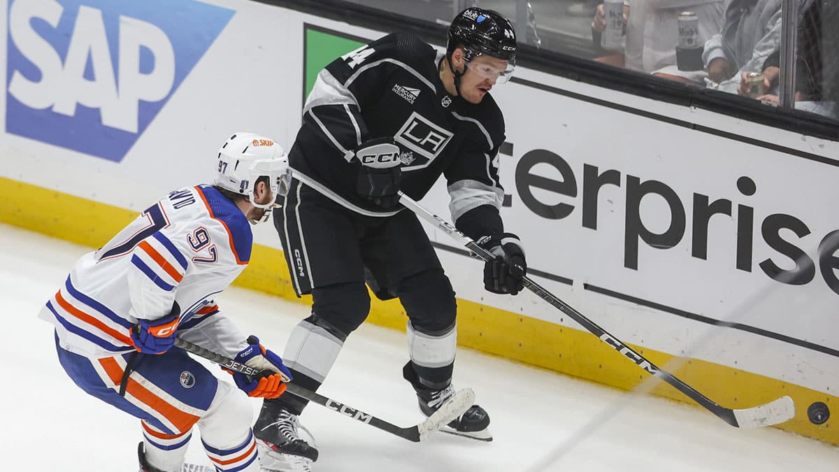 Los Angeles Kings defensemen Mikey Anderson (44) moves the puck as Edmonton Oilers center Connor McDavid (97) defends in the third period of game four of the first round of the 2024 Stanley Cup Playoffs at Crypto.com Arena.