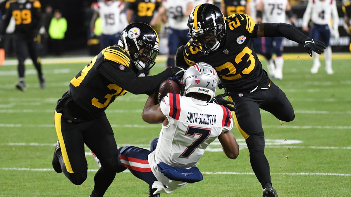 New England Patriots wide receiver JuJu Smith-Schuster (7) catches the ball between Pittsburgh Steelers safeties Minkah Fitzpatrick (39) and Damontae Kazee (23) during the first quarter at Acrisure Stadium.