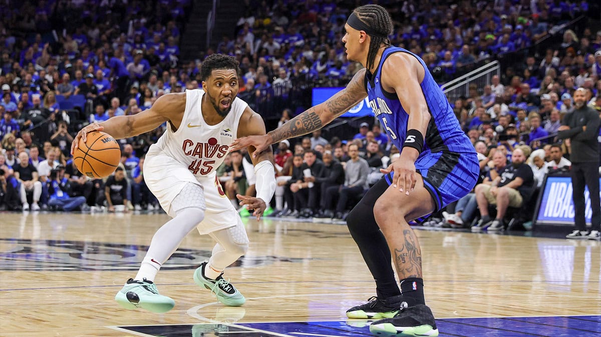 Cleveland Cavaliers guard Donovan Mitchell (45) handles the ball against Orlando Magic forward Paolo Banchero (5) during the second half of game six of the first round for the 2024 NBA playoffs at Kia Center.