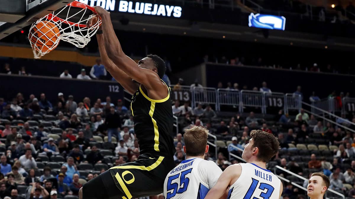 Oregon Ducks center N'Faly Dante (1) dunks the ball against Creighton Bluejays guard Baylor Scheierman (55) during the second half in the second round of the 2024 NCAA Tournament at PPG Paints Arena.
