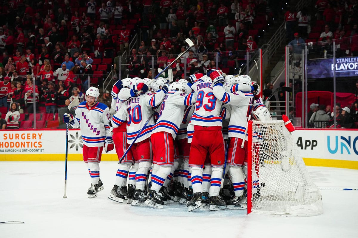 New York Rangers players celebrate their victory against the Carolina Hurricanes in game six of the second round of the 2024 Stanley Cup Playoffs at PNC Arena.