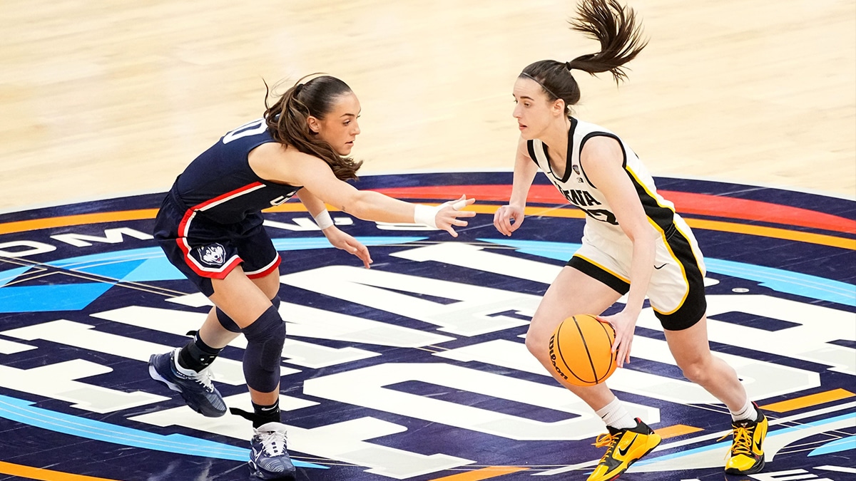 Iowa Hawkeyes guard Caitlin Clark (22) drives to the basket as UConn Huskies guard Nika Muhl (10) defends during the 2024 Final Four.