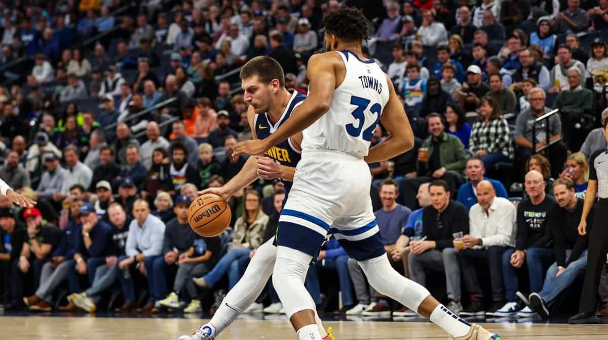 Denver Nuggets center Nikola Jokic (15) drives to the basket while Minnesota Timberwolves center Karl-Anthony Towns (32) defends