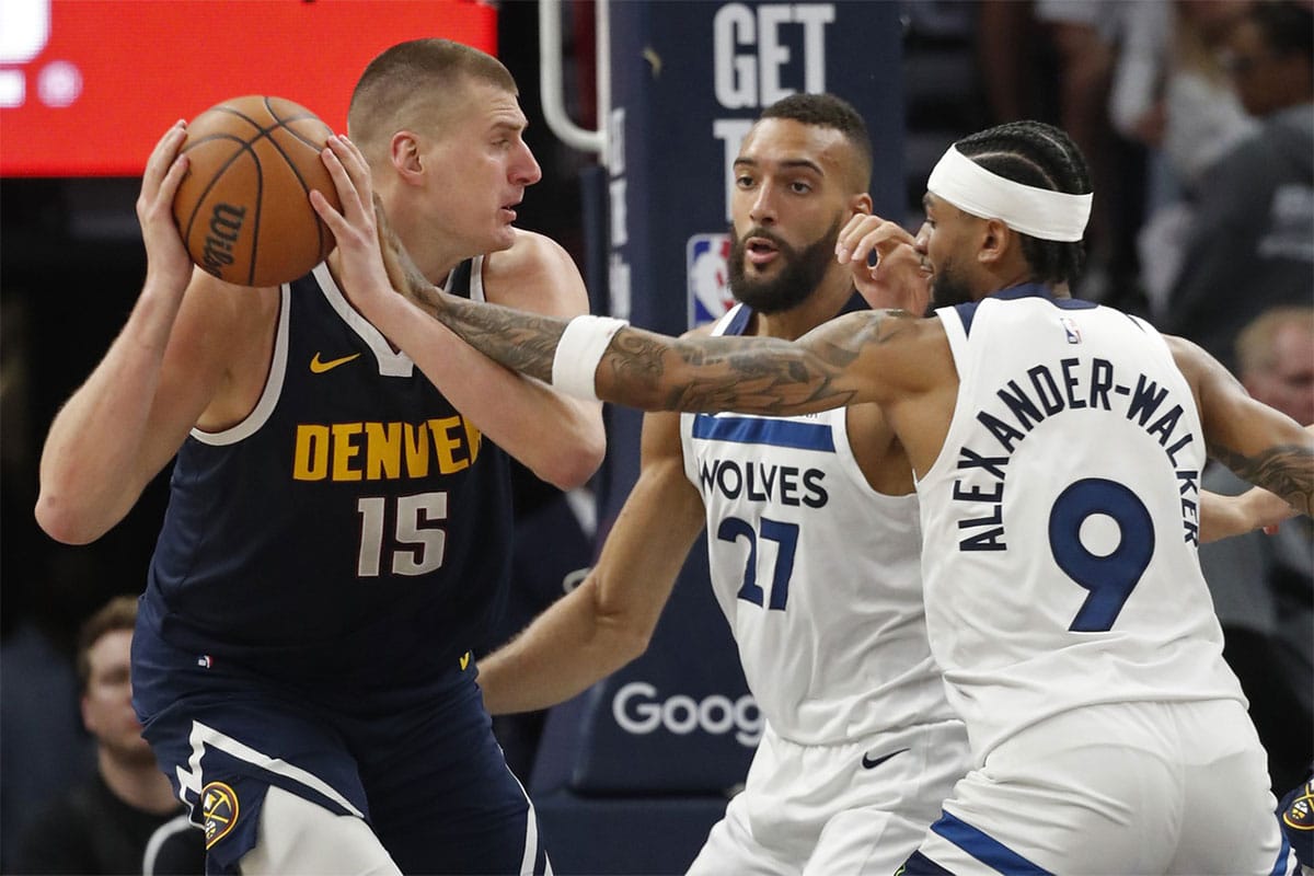 Denver Nuggets center Nikola Jokic (15) works around Minnesota Timberwolves center Rudy Gobert (27) and guard Nickeil Alexander-Walker (9) in the third quarter of game four of the second round for the 2024 NBA playoffs at Target Center. 