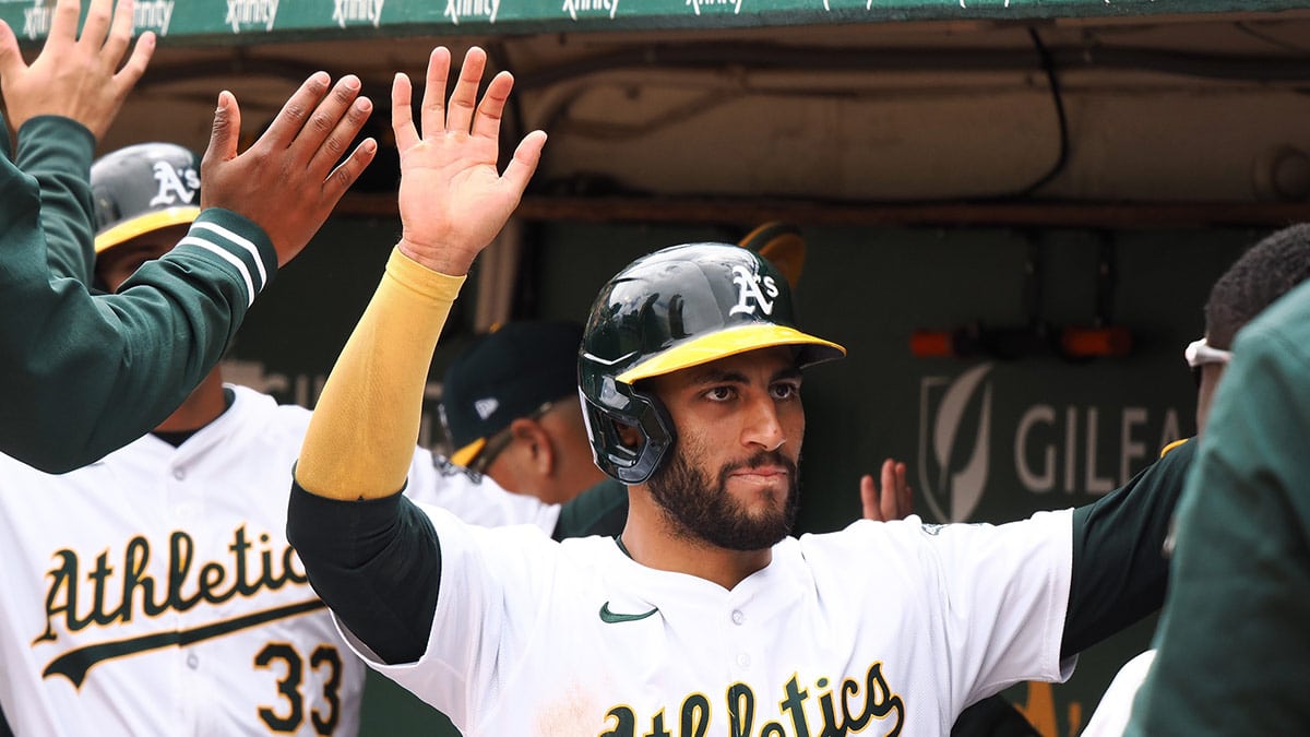 Oakland Athletics third baseman Abraham Toro (31) and center fielder JJ Bleday (33) high five teammates in the dugout after scoring against the Houston Astros during the first inning at Oakland-Alameda County Coliseum. 