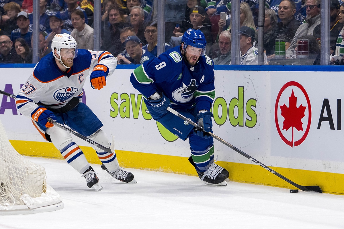 Vancouver Canucks forward J.T. Miller (9) controls the puck against Edmonton Oilers forward Connor McDavid (97) during the first period in game one of the second round of the 2024 Stanley Cup Playoffs at Rogers Arena.