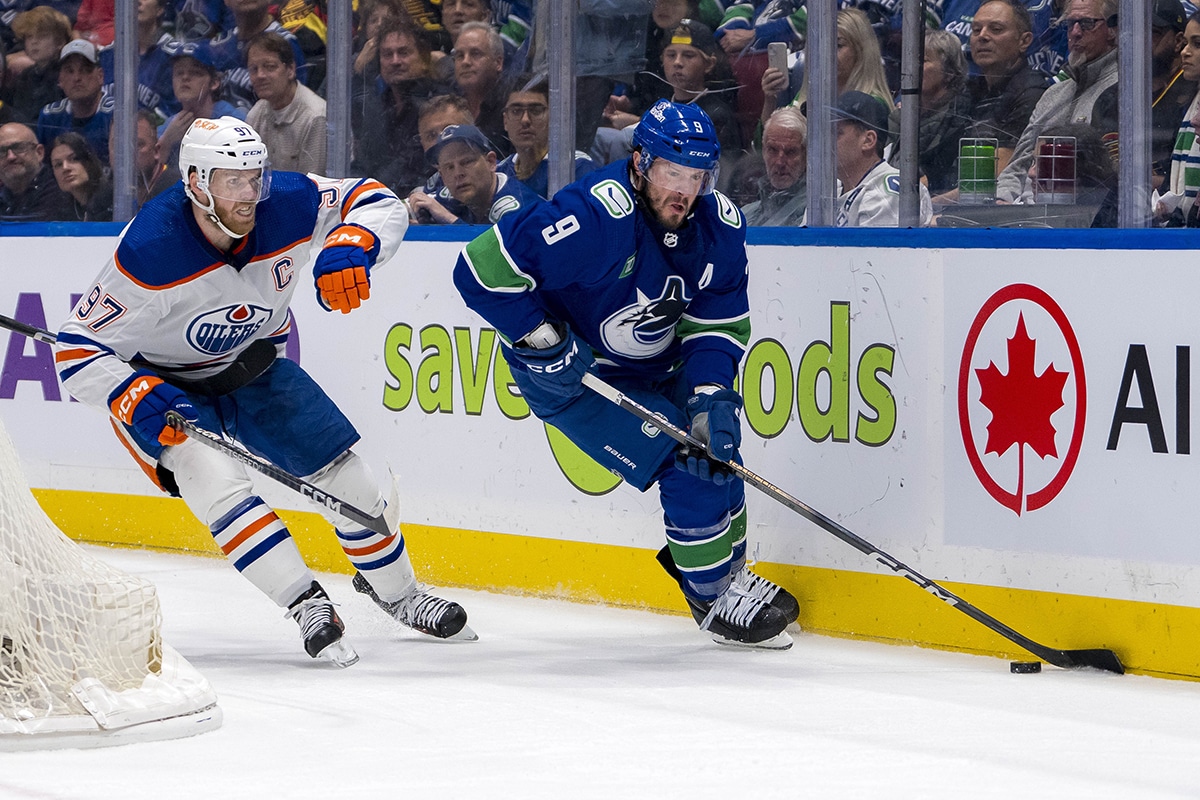 Vancouver Canucks forward J.T. Miller (9) controls the puck against Edmonton Oilers forward Connor McDavid (97) during the first period in game one of the second round of the 2024 Stanley Cup Playoffs at Rogers Arena.