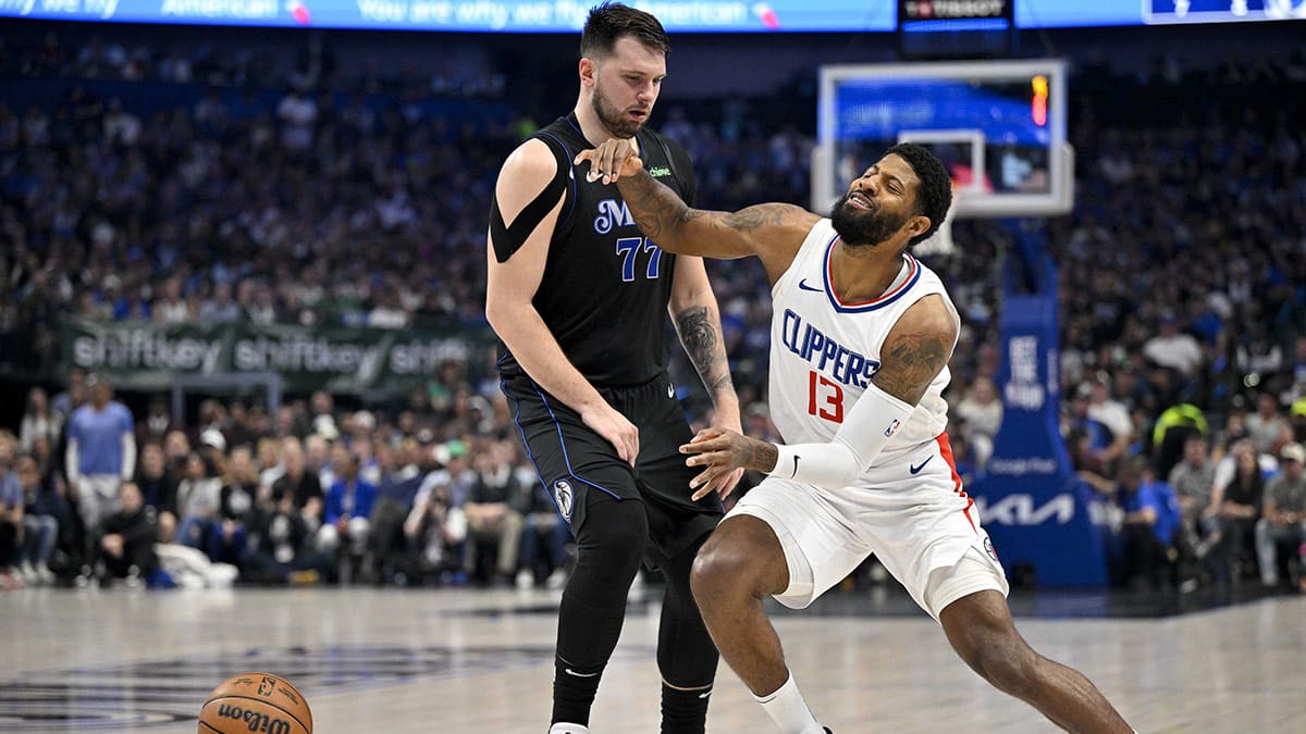 LA Clippers forward Paul George (13) is fouled by Dallas Mavericks guard Luka Doncic (77) during the first quarter during game six of the first round for the 2024 NBA playoffs at American Airlines Center. 