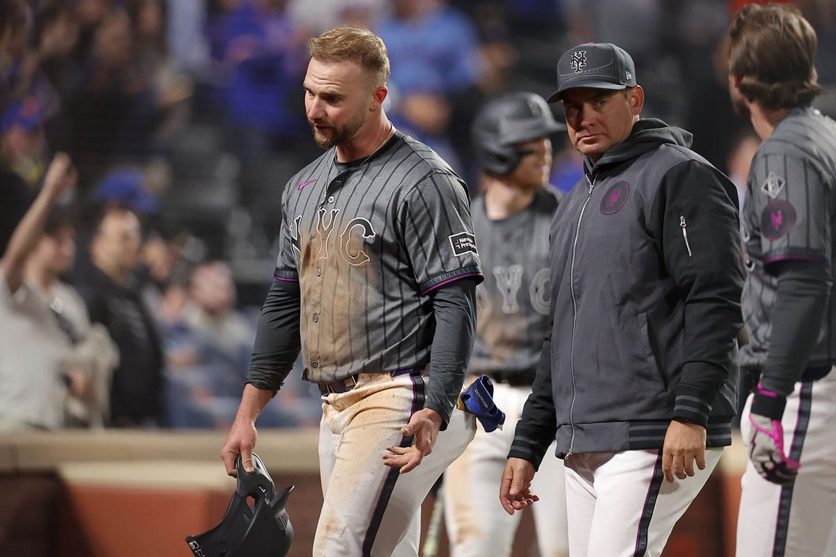 New York Mets first baseman Pete Alonso (20) reacts with manager Carlos Mendoza (64) after being tagged out at home to end the game while trying to score on a fly ball by second baseman Jeff McNeil (1) during the ninth inning against the Chicago Cubs at Citi Field. The play was upheld after a video replay
