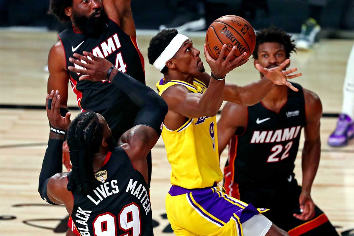 Los Angeles Lakers guard Rajon Rondo (9) drives to the basket against Miami Heat forward Jae Crowder (99) and forward Jimmy Butler (22) during the fourth quarter in game one of the 2020 NBA Finals at AdventHealth Arena.