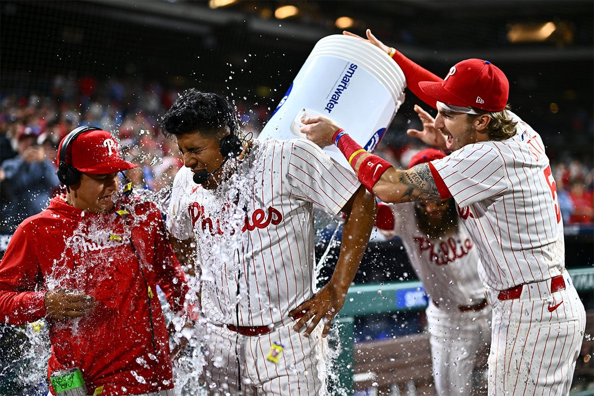 Philadelphia Phillies starting pitcher Ranger Suarez (55) is showered by second baseman Bryson Stott (5) and outfielder Brandon Marsh (16) after pitching a complete game shutout against the Colorado Rockies at Citizens Bank Park.