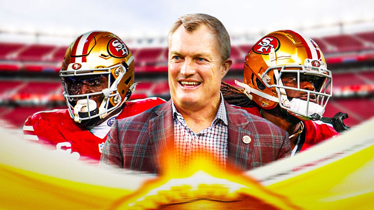 San Francisco 49ers GM John Lynch with wide receivers Deebo Samuel and Brandon Aiyuk. They are next to a logo for the San Francisco 49ers.