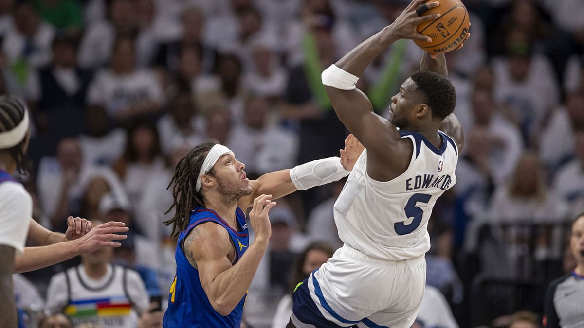 Minnesota Timberwolves guard Anthony Edwards (5) jumps up and attempts to pass the ball over Denver Nuggets forward Aaron Gordon (50) in the first half during game three of the second round for the 2024 NBA playoffs at Target Center.