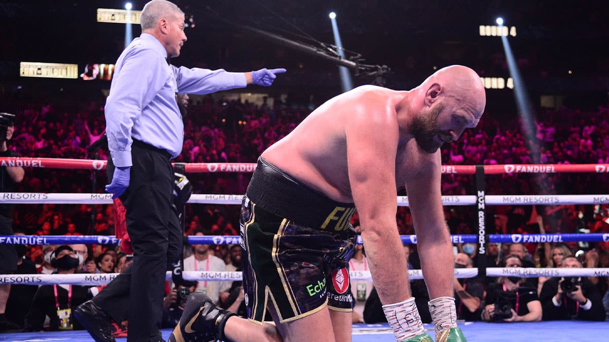 Oct 9, 2021; Las Vegas, Nevada, USA; Deontay Wilder (red/black trunks) knocks down Tyson Fury (black/gold trunks) during their WBC/Lineal heavyweight championship boxing match at T-Mobile Arena. 