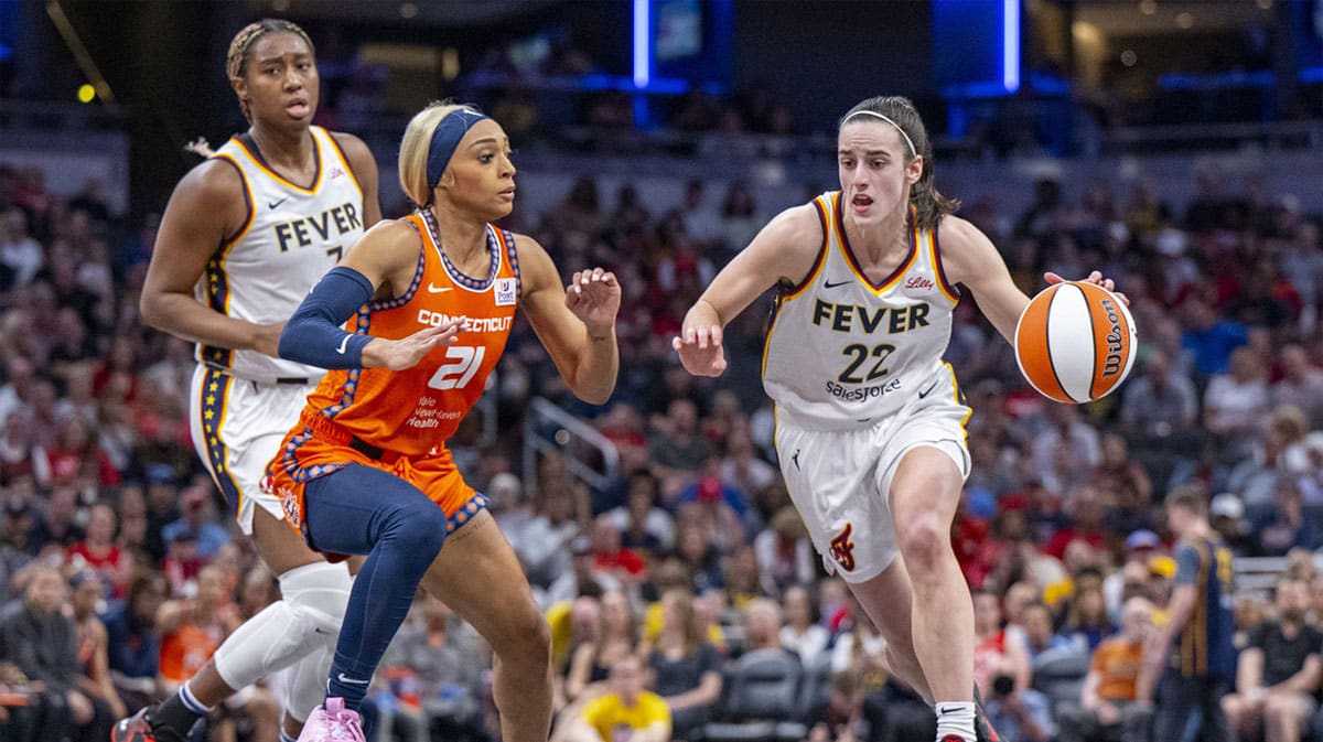 Indiana Fever guard Caitlin Clark (22) brings the ball up court while being defended by Connecticut Sun guard DiJonai Carrington (21) during the first half of an WNBA basketball game, Monday, May 20, 2024, at Gainbridge Fieldhouse.