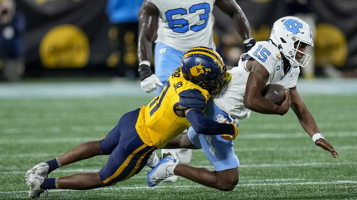 West Virginia Mountaineers cornerback Beanie Bishop Jr. (11) tackles North Carolina Tar Heels quarterback Conner Harrell (15) during the first half at Bank of America Stadium.