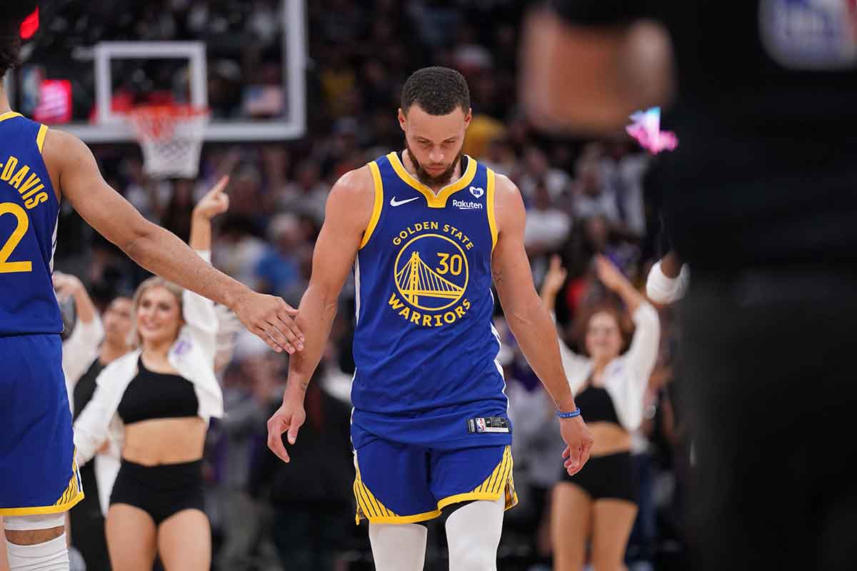 Golden State Warriors guard Stephen Curry (30) walks towards the team bench during a timeout against the Sacramento Kings in the fourth quarter during a play-in game of the 2024 NBA playoffs at the Golden 1 Center