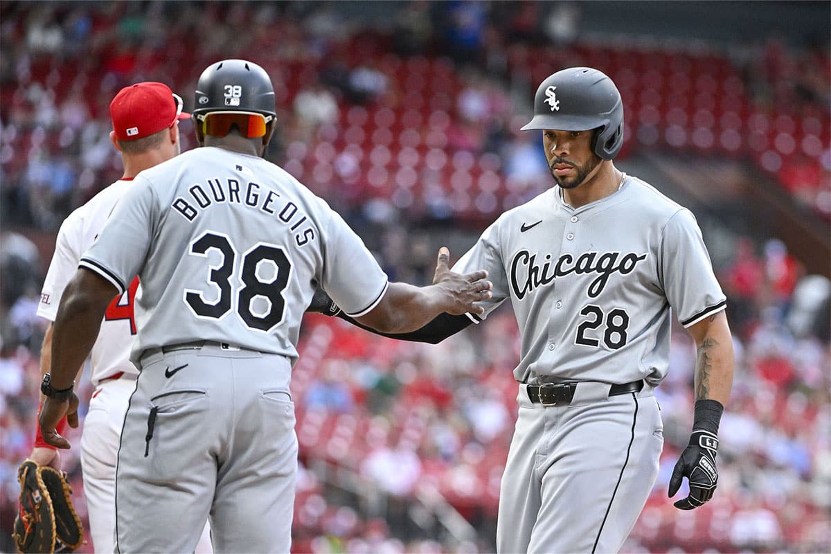 Chicago White Sox right fielder Tommy Pham (28) is congratulated by first base coach Jason Bourgeois (38) after hitting a go-ahead one run single against the St. Louis Cardinals during the tenth inning at Busch Stadium.
