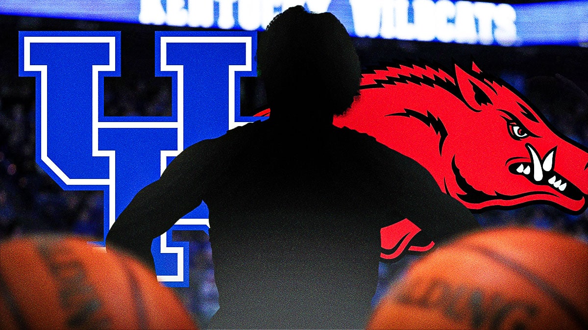 Ex five-star Kentucky basketball guard DJ Wagner stands next to Arkansas logo, John Calipari in background