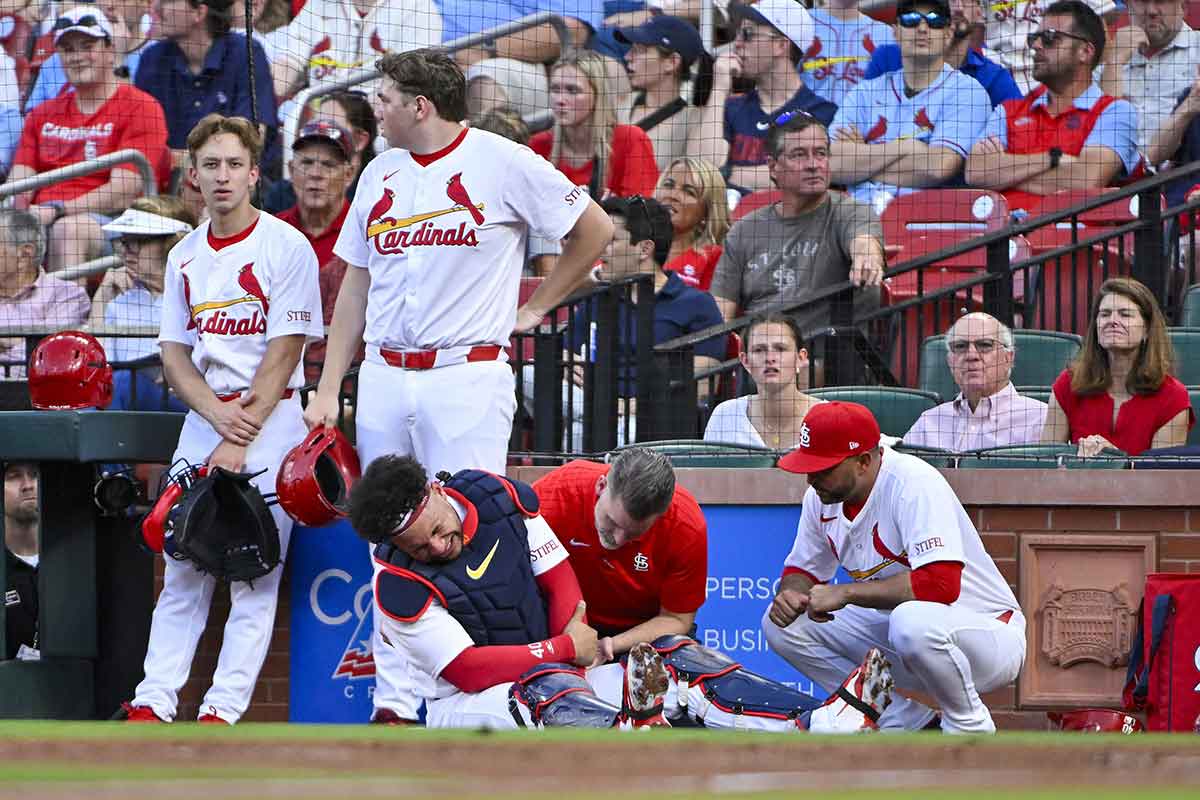 St. Louis Cardinals catcher Willson Contreras (40) is checked on by a trainer and manager Oliver Marmol (37) after fracturing his left arm during the second inning against the New York Mets at Busch Stadium