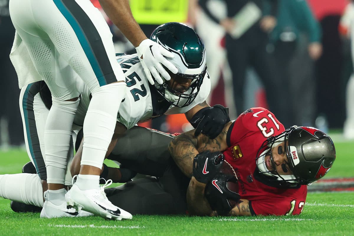 Philadelphia Eagles linebacker Zach Cunningham (52) tackles Tampa Bay Buccaneers wide receiver Mike Evans (13) after a catch during the first half of a 2024 NFC wild card game at Raymond James Stadium