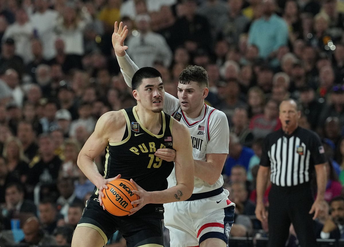 Purdue Boilermakers center Zach Edey (15) is defended by Connecticut Huskies center Donovan Clingan (32) in the national championship game of the Final Four of the 2024 NCAA Tournament at State Farm Stadium. 