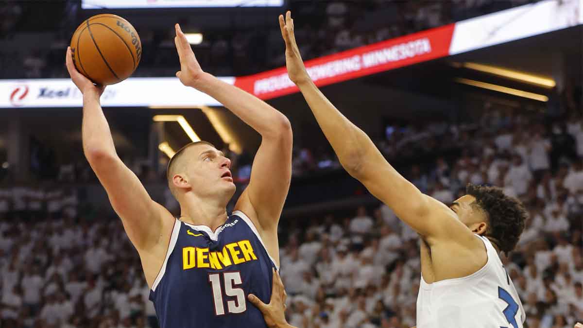Denver Nuggets center Nikola Jokic (15) goes to the basket against Minnesota Timberwolves forward Karl-Anthony Towns (32) in the first quarter of game four of the second round for the 2024 NBA playoffs at Target Center.