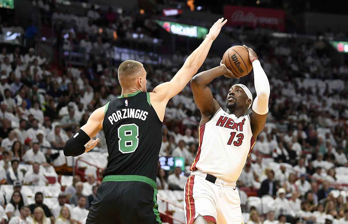Apr 29, 2024; Miami, Florida, USA; Miami Heat center Bam Adebayo (13) shoots over Boston Celtics center Kristaps Porzingis (8) during the first quarter of game four of the first round for the 2024 NBA playoffs at Kaseya Center. Mandatory Credit: Michael Laughlin-USA TODAY Sports