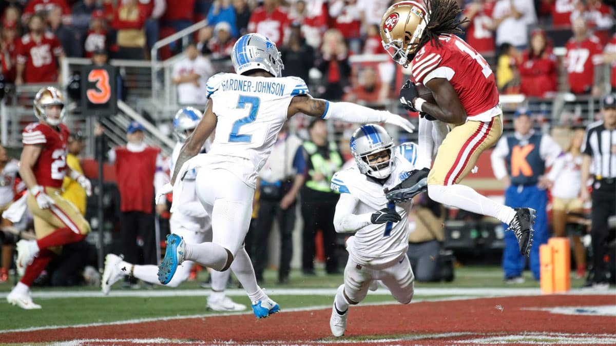49ers wide receiver Brandon Aiyuk catches the ball around Lions defensive backs C.J. Gardner-Johnson, left, and Cam Sutton for a touchdown in the third quarter of the Lions' 34-31 loss in the NFC championship game in Santa Clara, California, on Jan. 28, 2024.