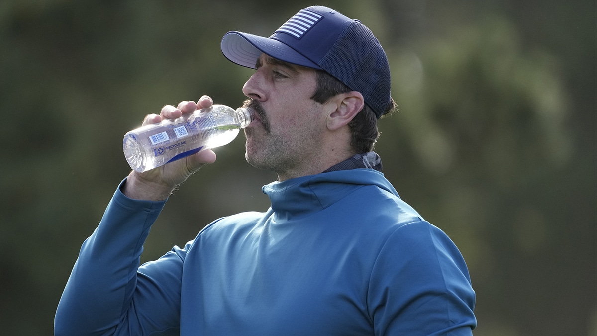 New York Jets quarterback Aaron Rodgers drinks water on the 11th hole during the first round of the AT&T Pebble Beach Pro-Am golf tournament at Spyglass Hill Golf Course.