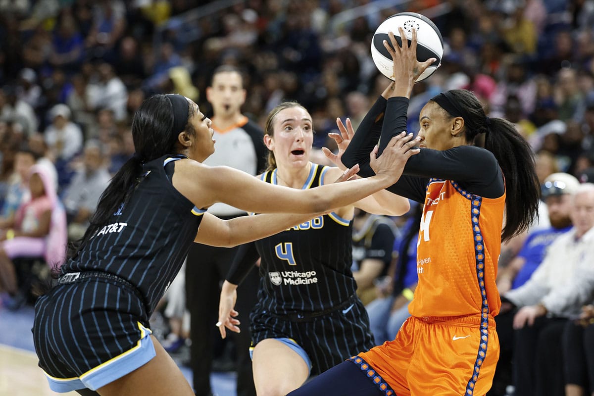 Connecticut Sun forward DeWanna Bonner (24) is defended by Chicago Sky forward Angel Reese (5) and guard Marina Mabrey (4) 