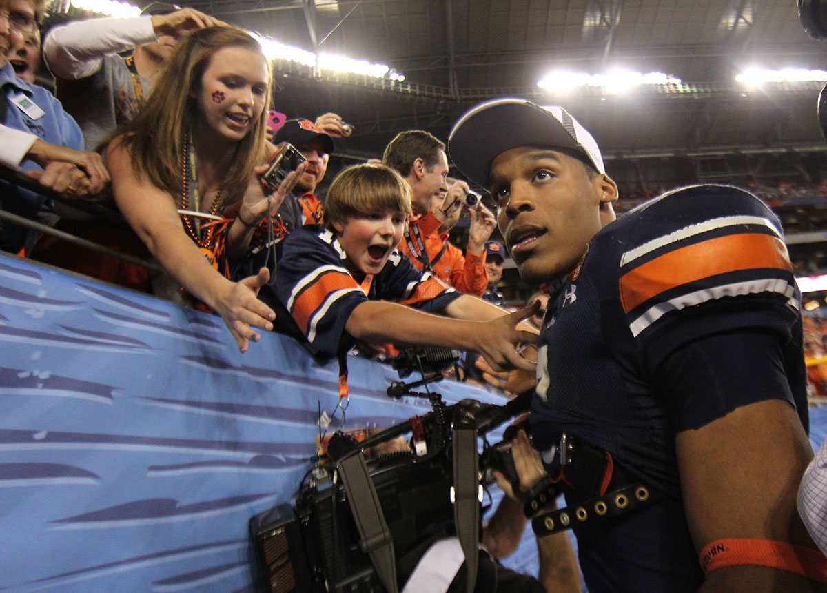 Auburn Tigers quarterback Cam Newton (2) celebrates with fans after the 2011 BCS National Championship game against the Oregon Ducks at University of Phoenix Stadium. The Tigers defeated the Ducks 22-19. 